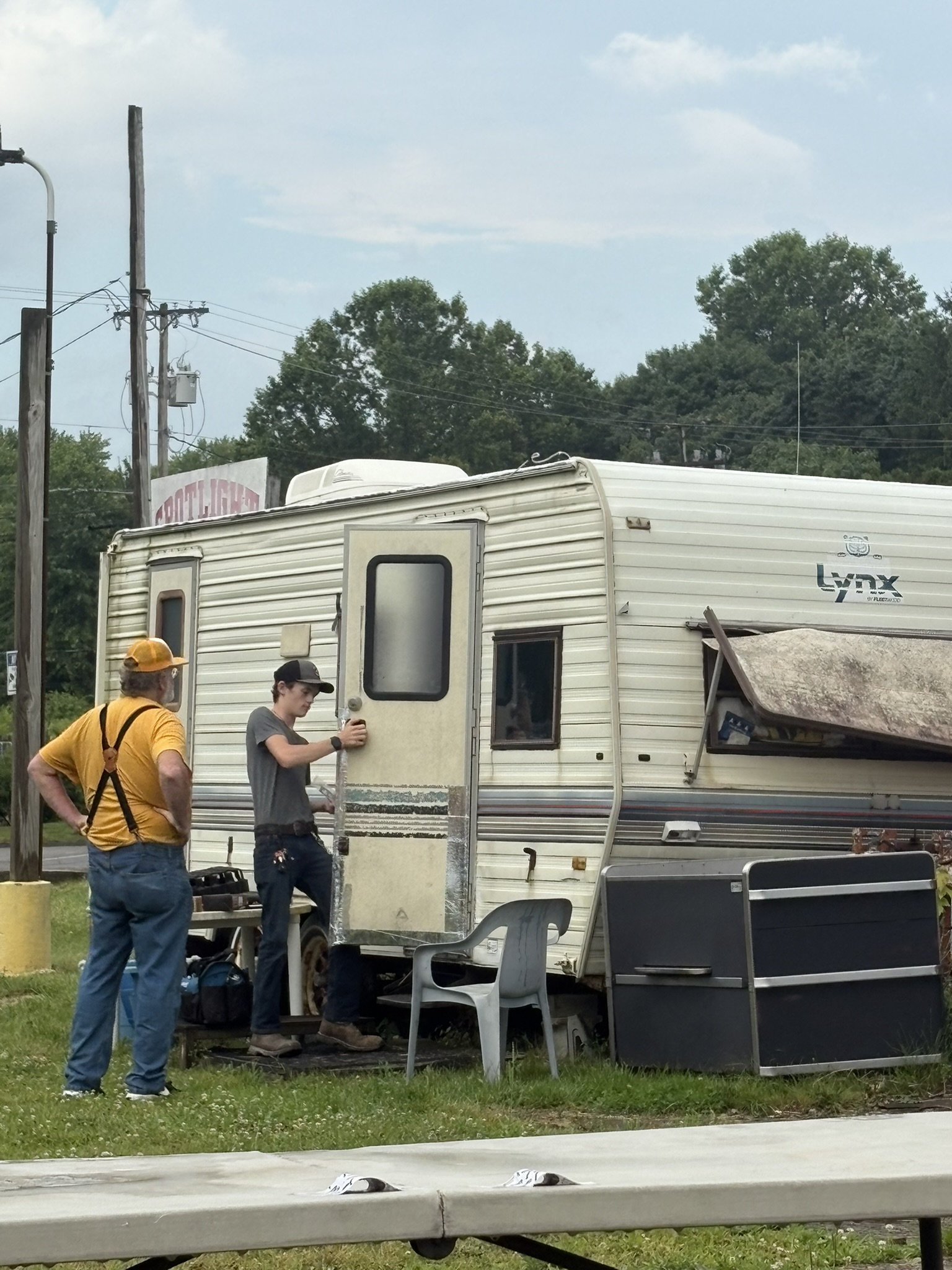 Andrew inspecting an older travel trailer exterior door and camper body